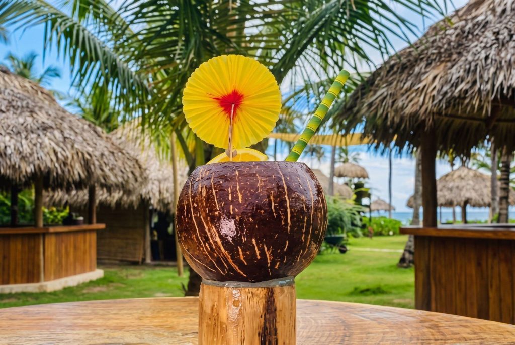 Cóctel servido en un coco con sombrilla amarilla en el Bar Brisas