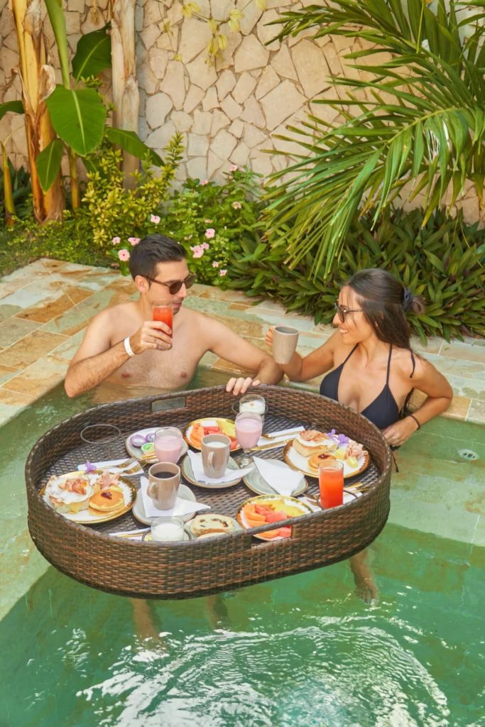 Pareja disfruta el desayuno en una piscina