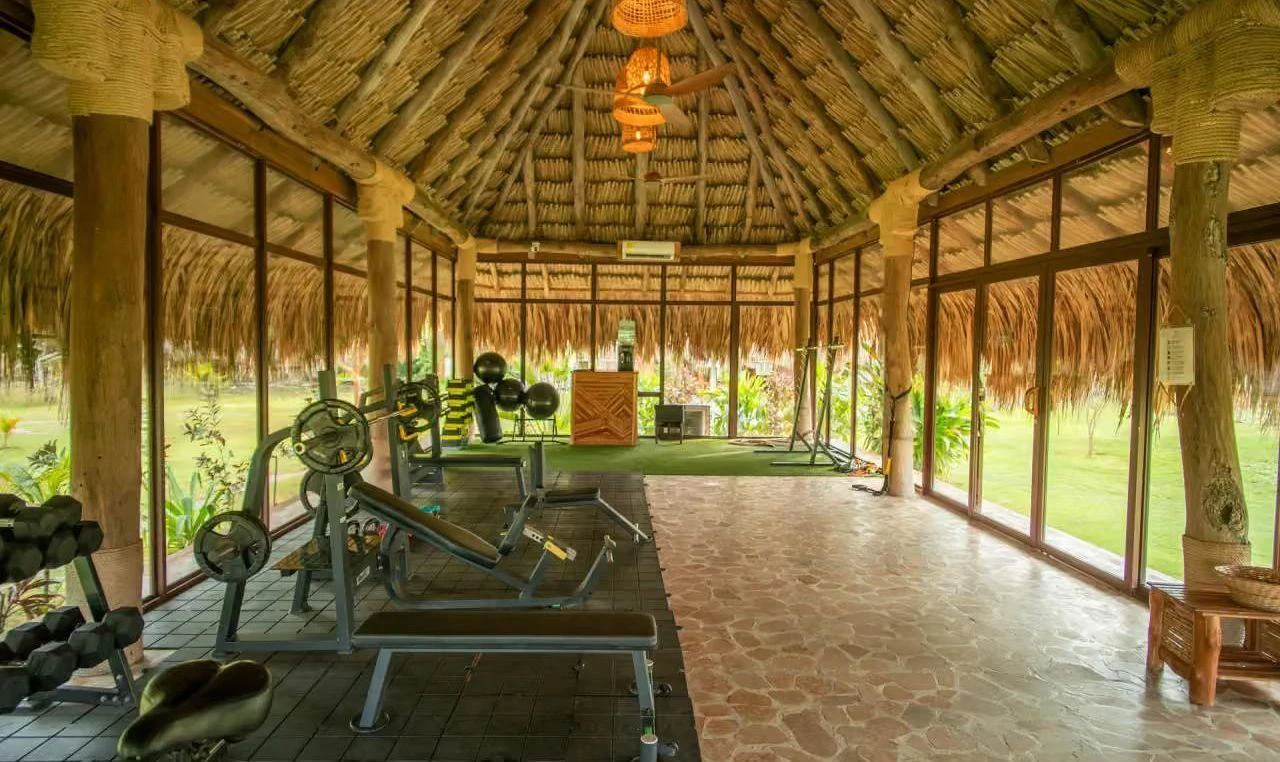 Interior del gimnasio con barra olímpica y mancuernas