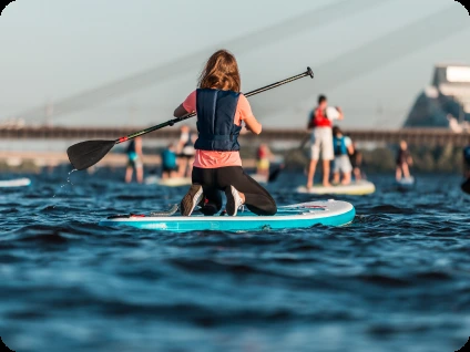 Person paddleboarding during the day pass